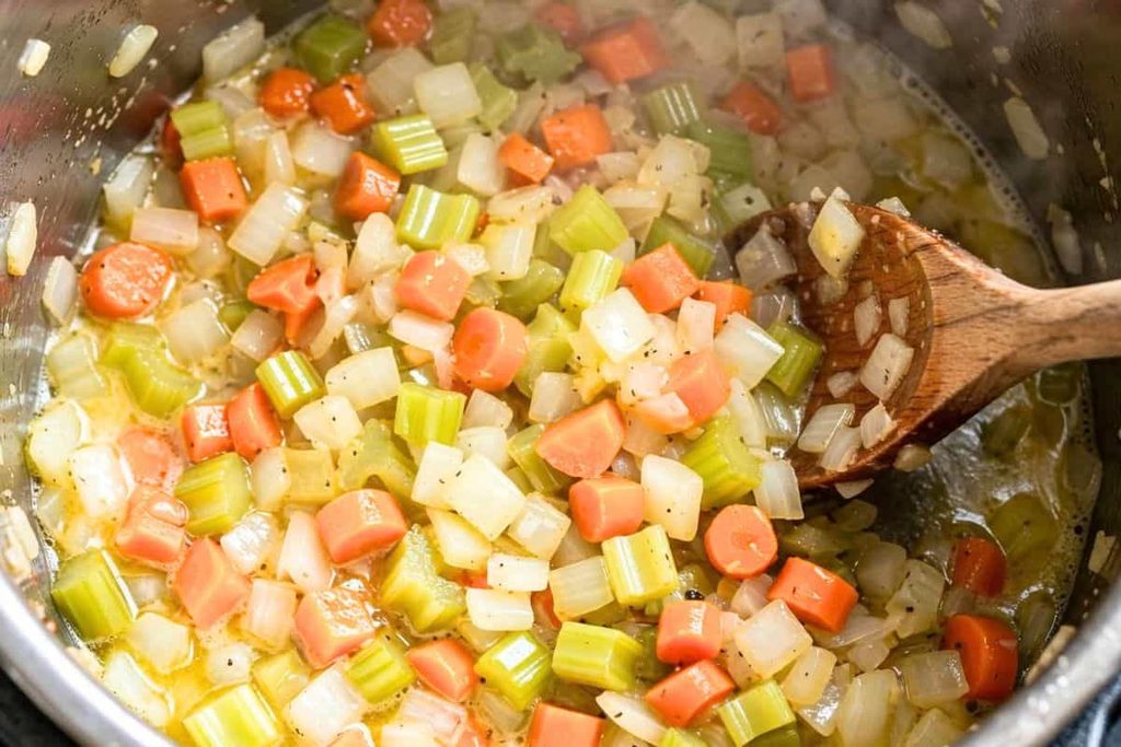 Carrots celery and onions sautéing for broccoli cheddar soup