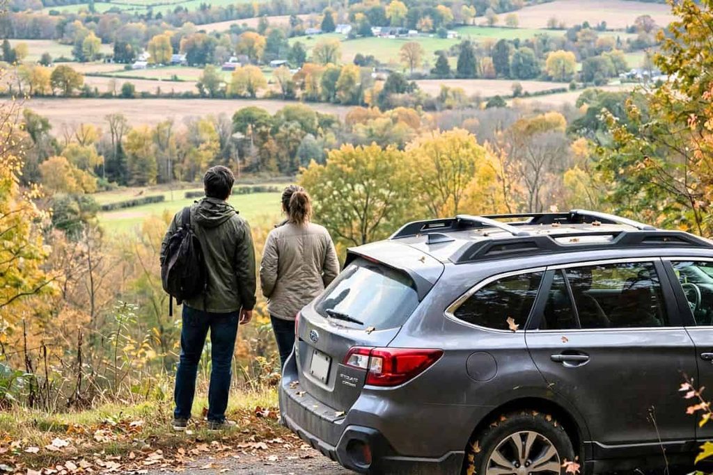 Couple enjoying colorful fall foliage during a scenic autumn drive.
