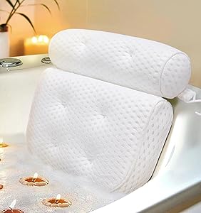 White cushioned bath pillow with headrest attached to a bathtub, surrounded by bubbles and floating candles for a relaxing spa-like setting.