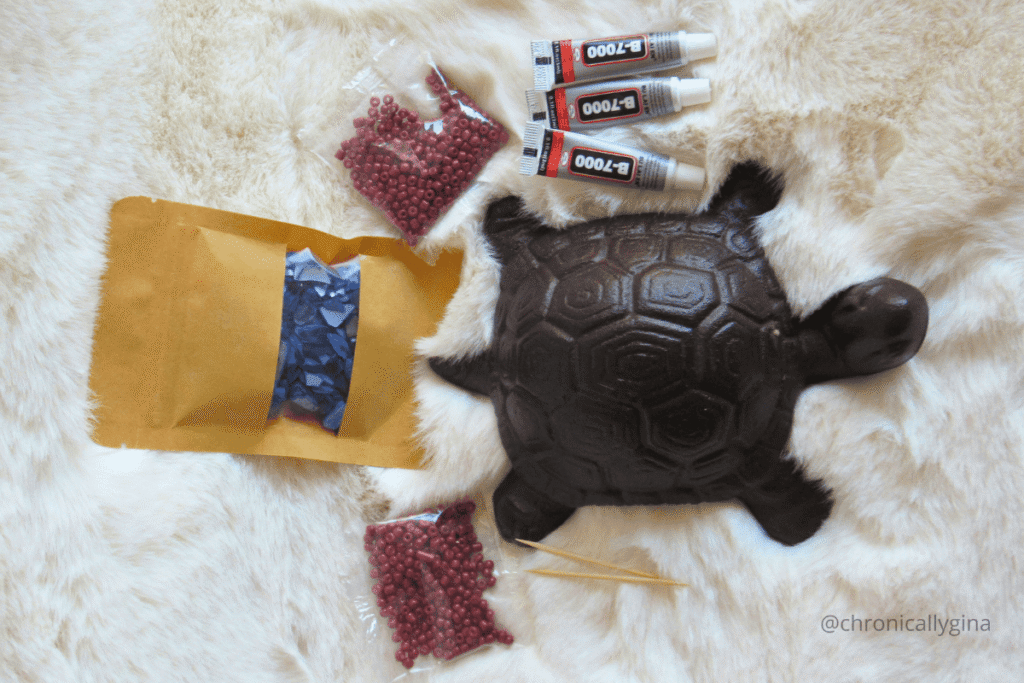 The Craftaurant turtle mosaic craft kit with beads, tiles, glue, and tools displayed on a cozy fur background, a creative hands-on gift idea featured in a holiday gift guide by budget.